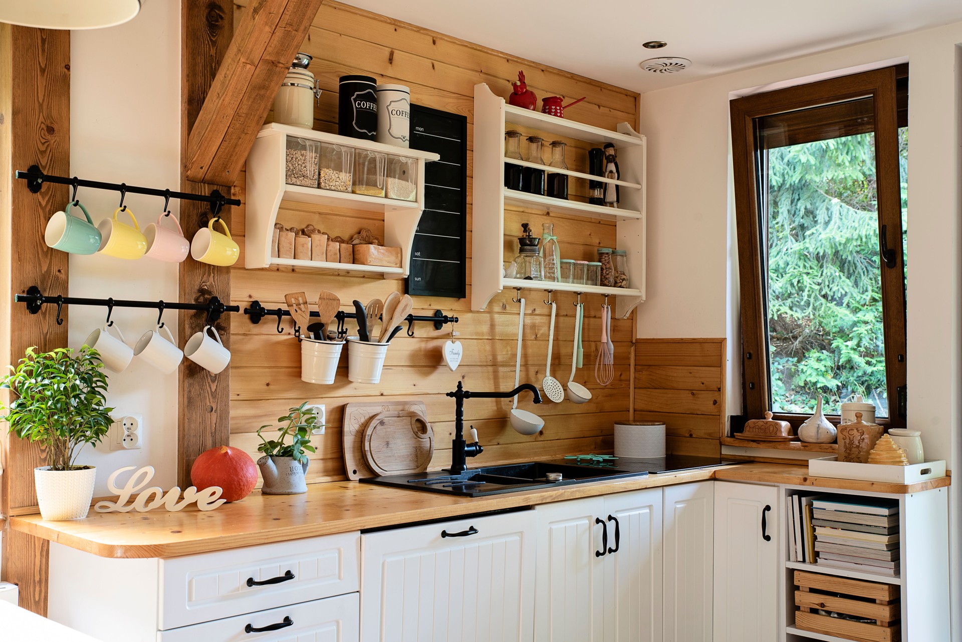 Interior of kitchen in cottage with window. Home decor with wood design and furniture. Rustic decoration.
